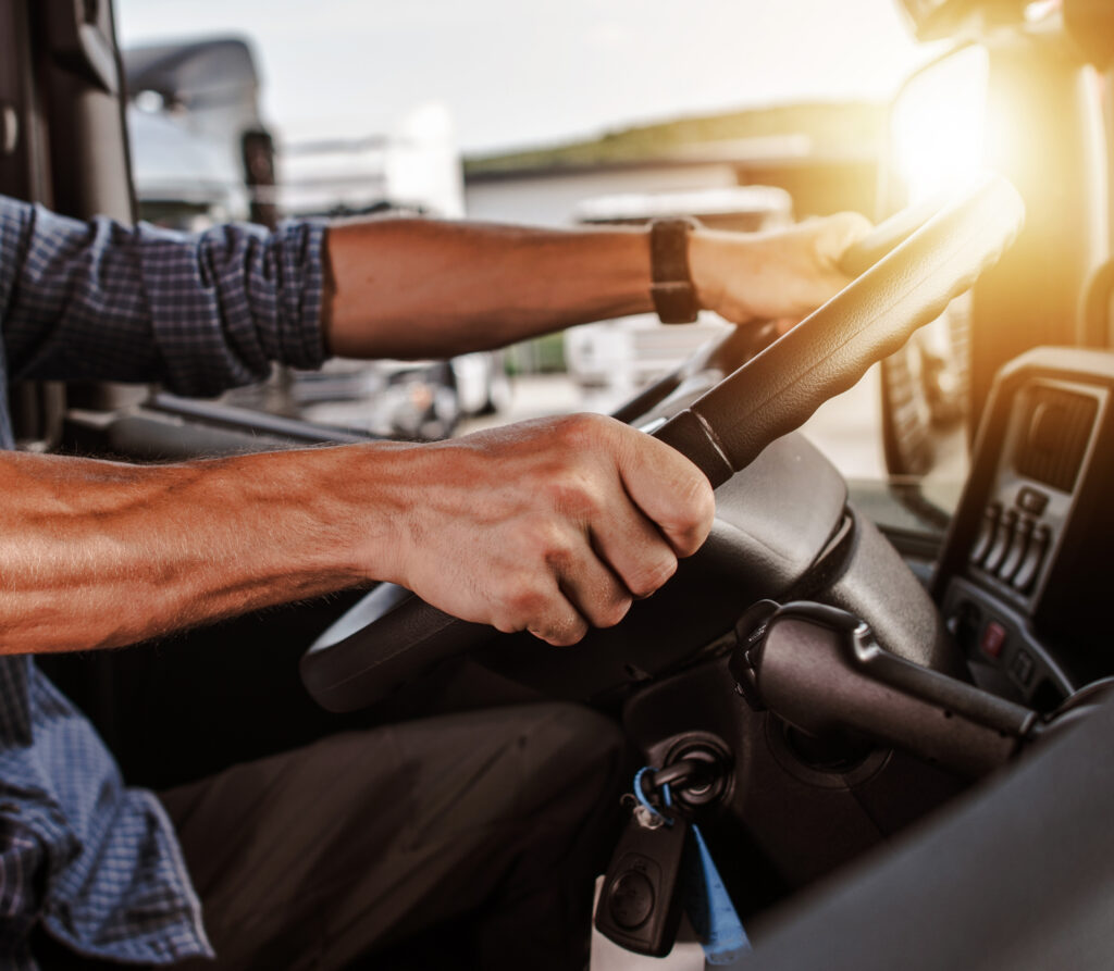 semi truck driver hands on the steering wheel